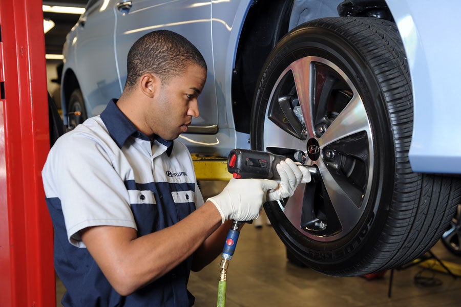 Hyundai Service Technician working on a car tire