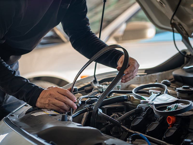 Service Technician replacing a car belt