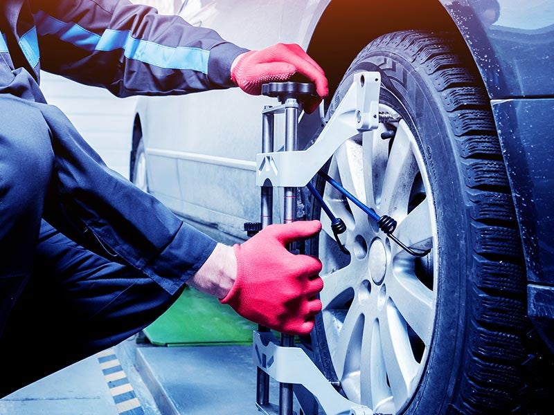 Service Technician aligning a car wheel